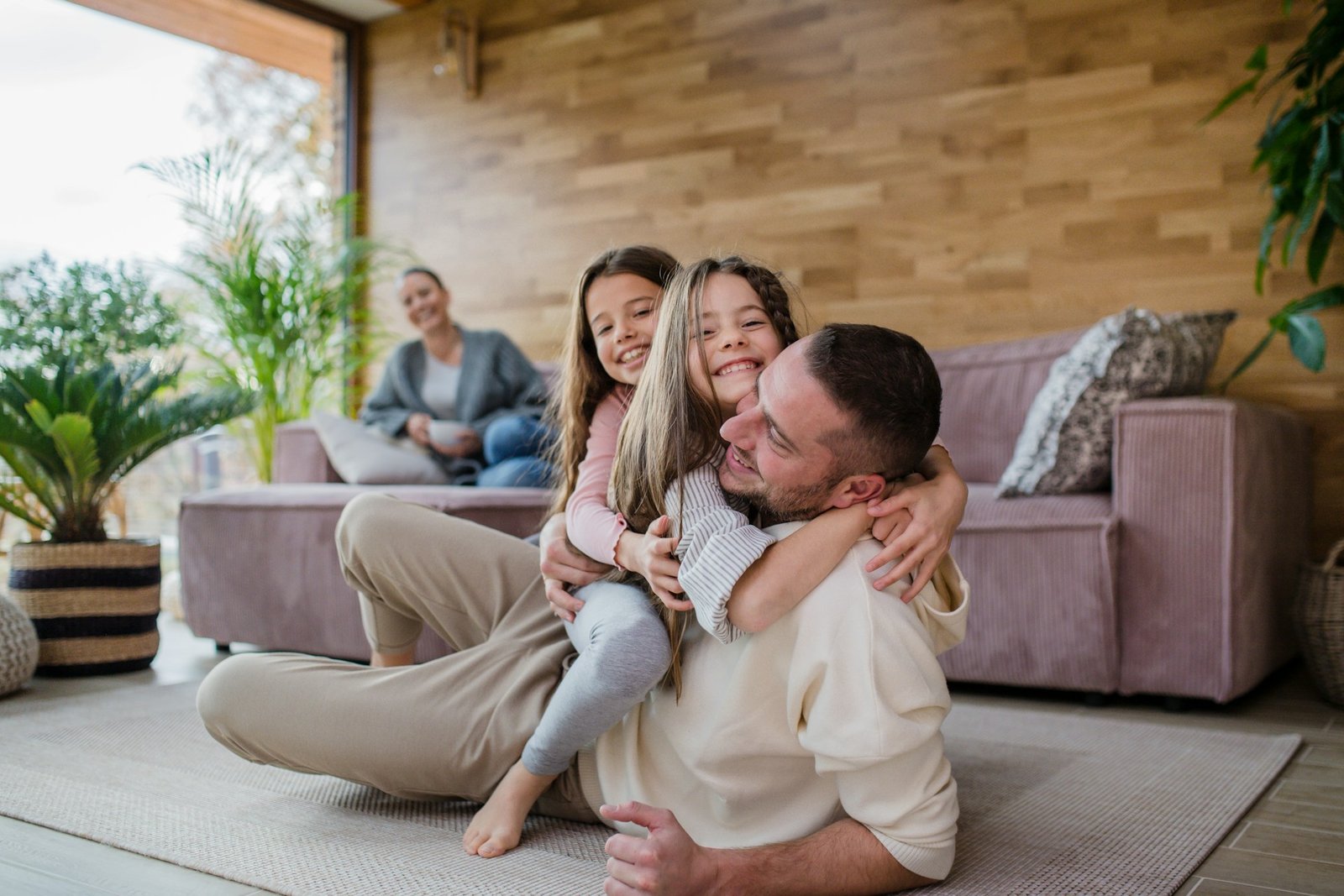 Une famille se retrouve avec joie devant sa maison, protégée par les assurances habitation et auto Credifa