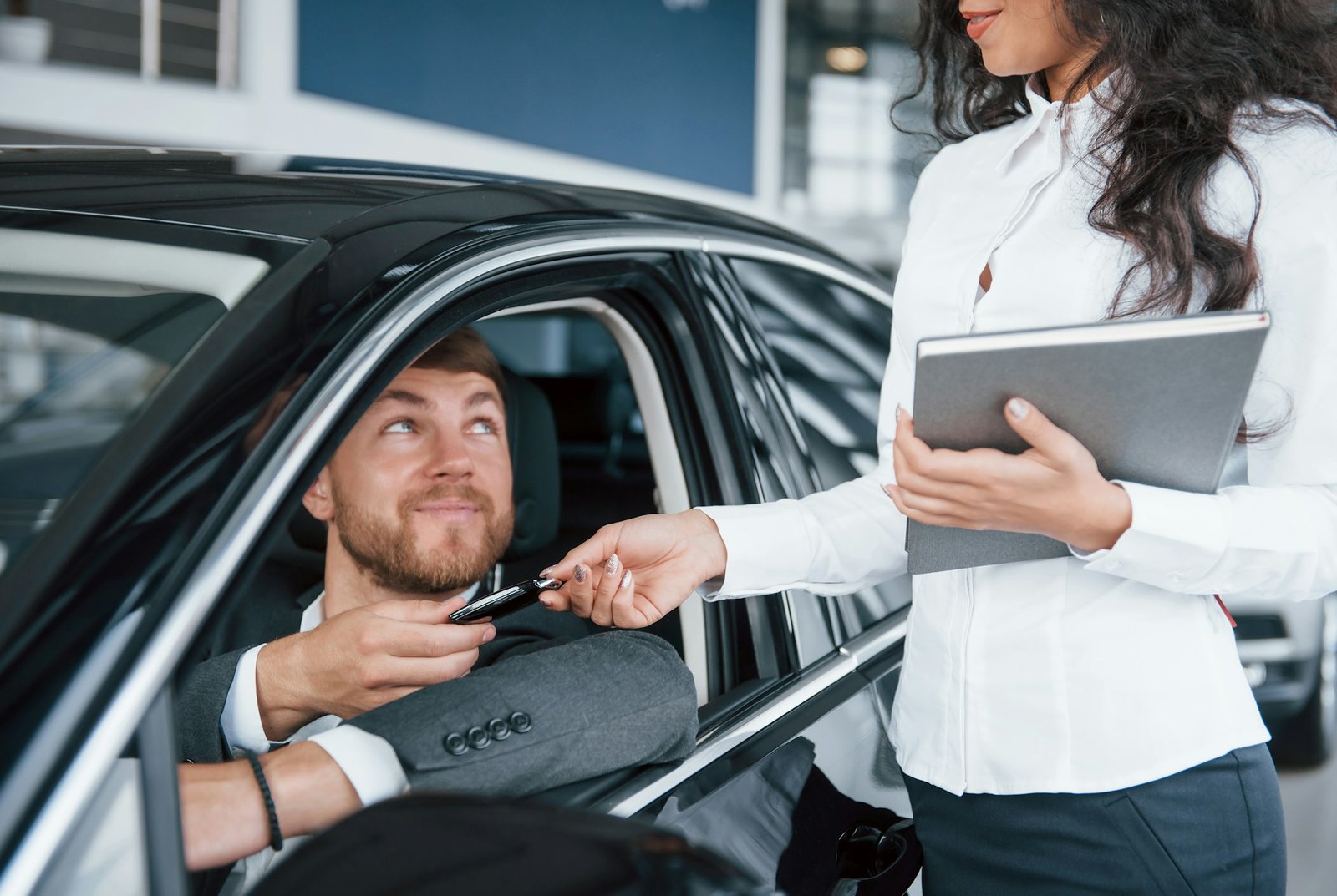 Un client reçoit les clés de sa nouvelle voiture chez le concessionnaire, financée par un crédit auto Credifa